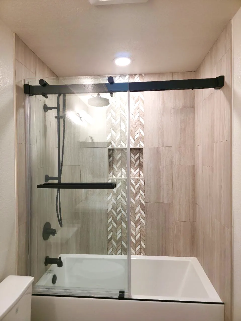 After: tub-shower with recessed niche seen through the sliding glass