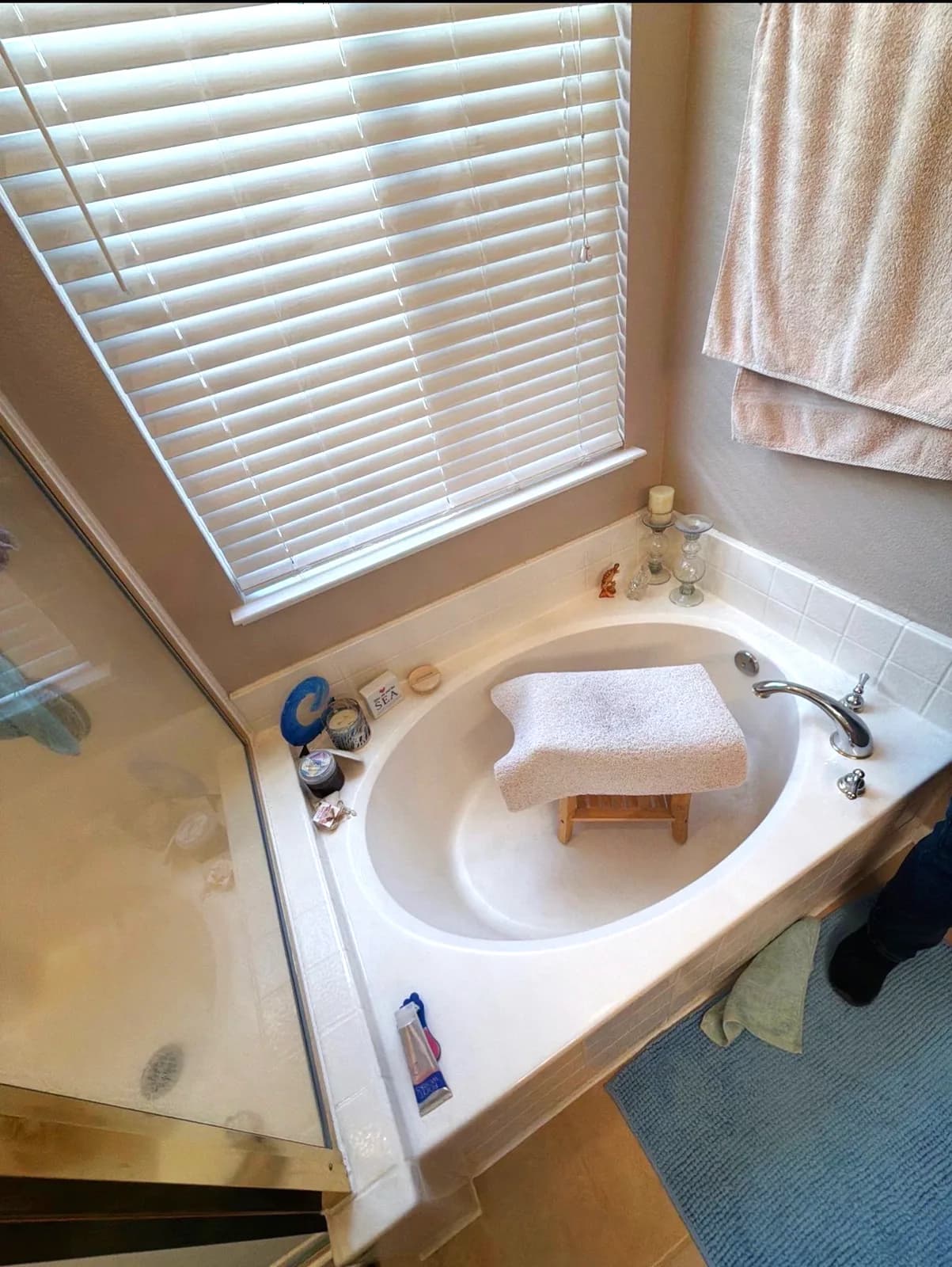 Before: framed shower stall with clouded glass next to the corner tub