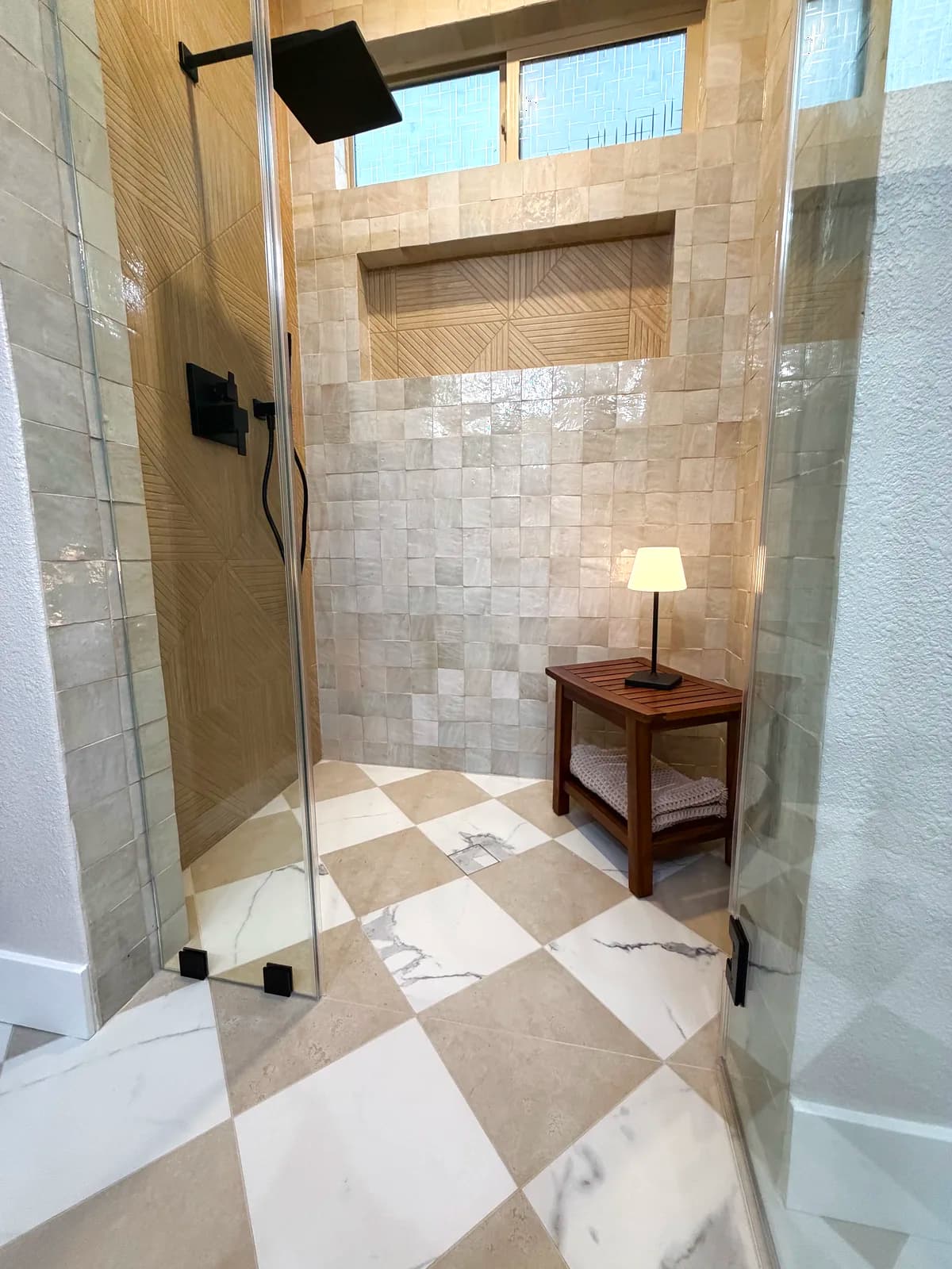 After: teak bench and wood-look chevron floor in the zellige-tiled shower