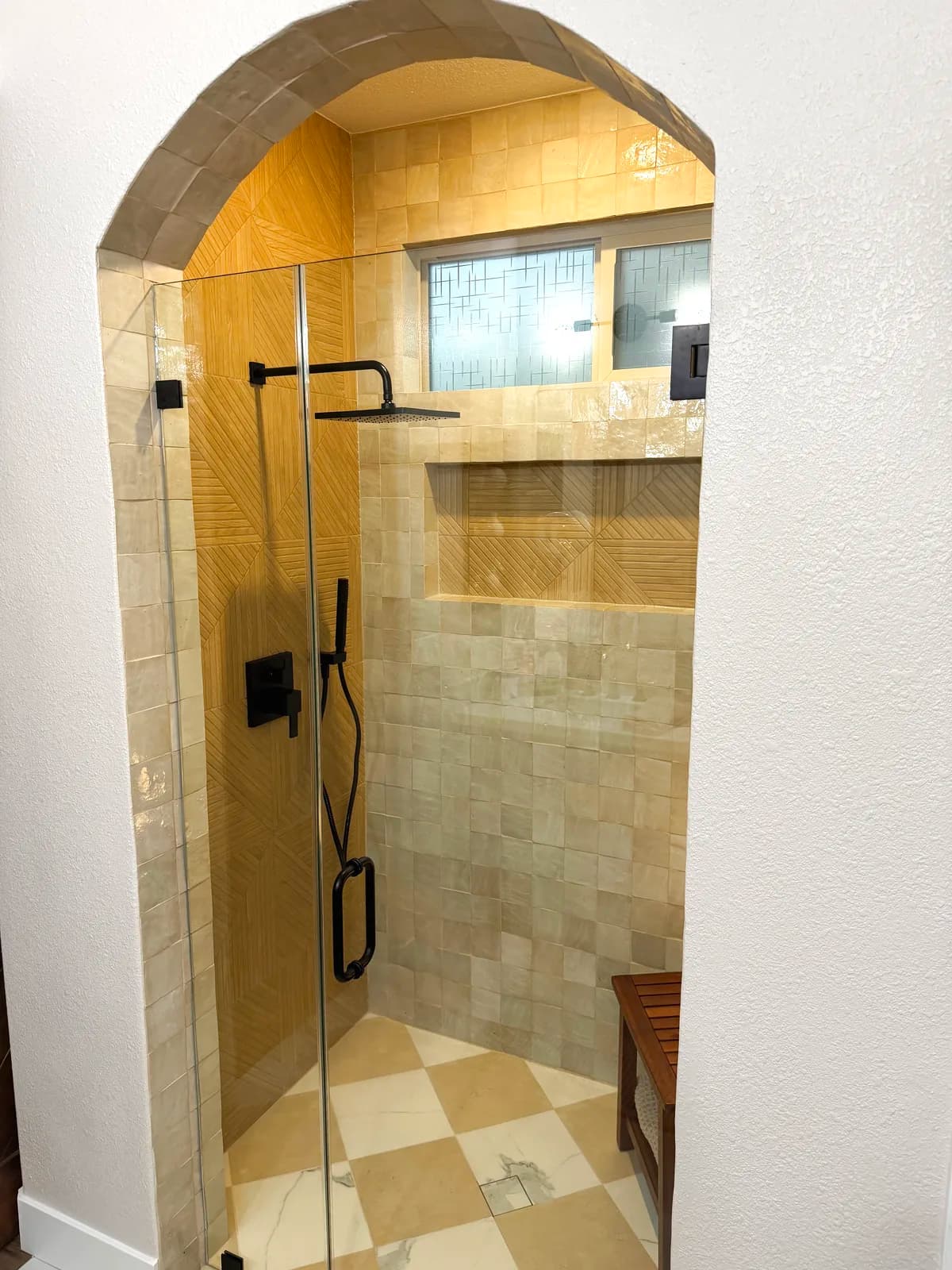 After: view through the arch to the handheld shower and niche