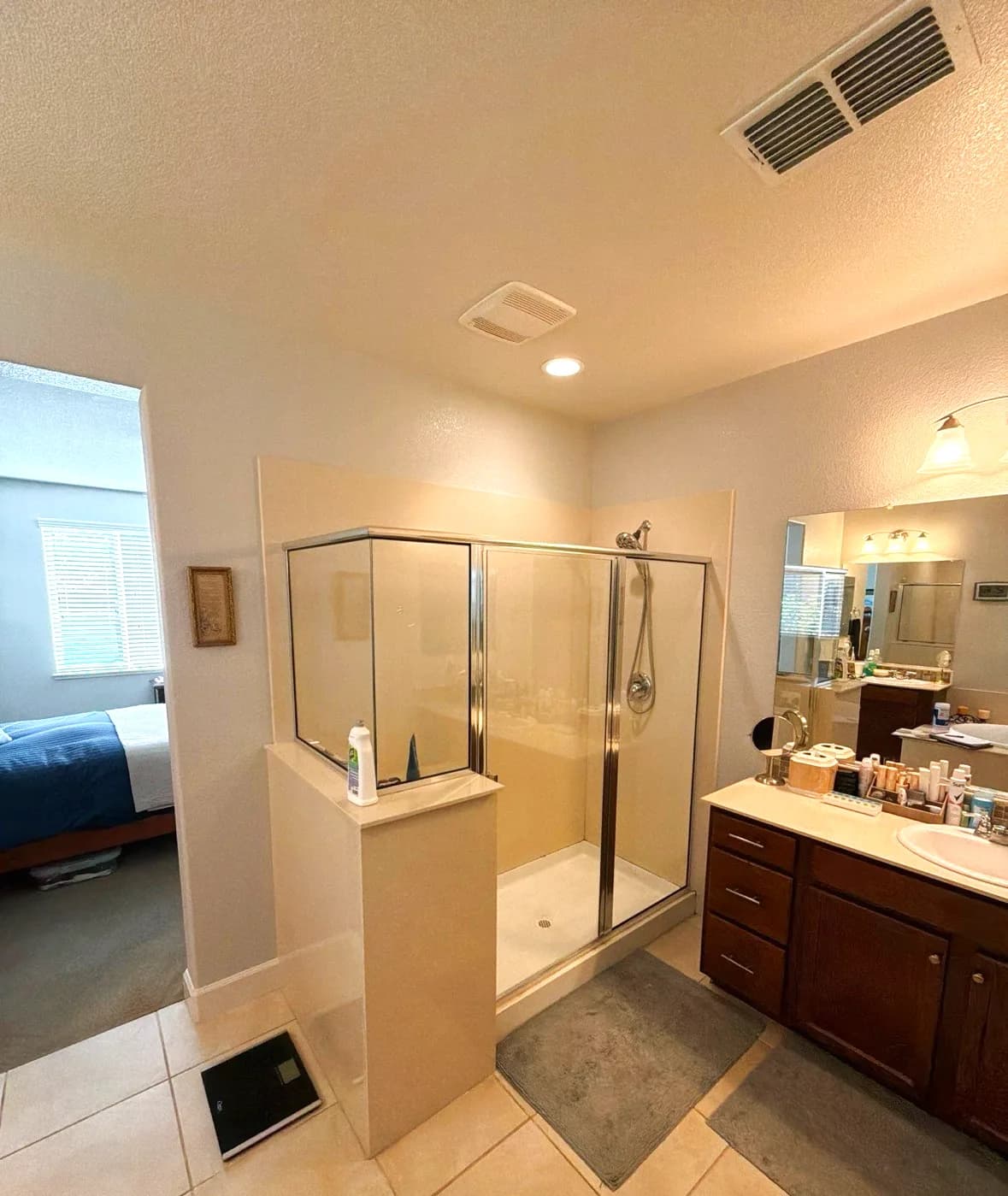 Before: framed corner shower stall with tiled half wall in an El Dorado Hills master bathroom