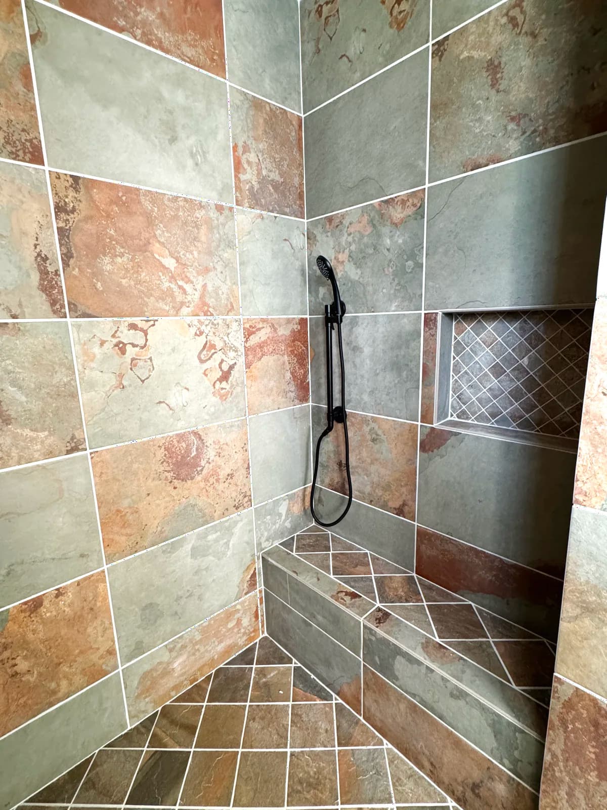 After: shower interior with recessed niche, bench and handheld on slide bar