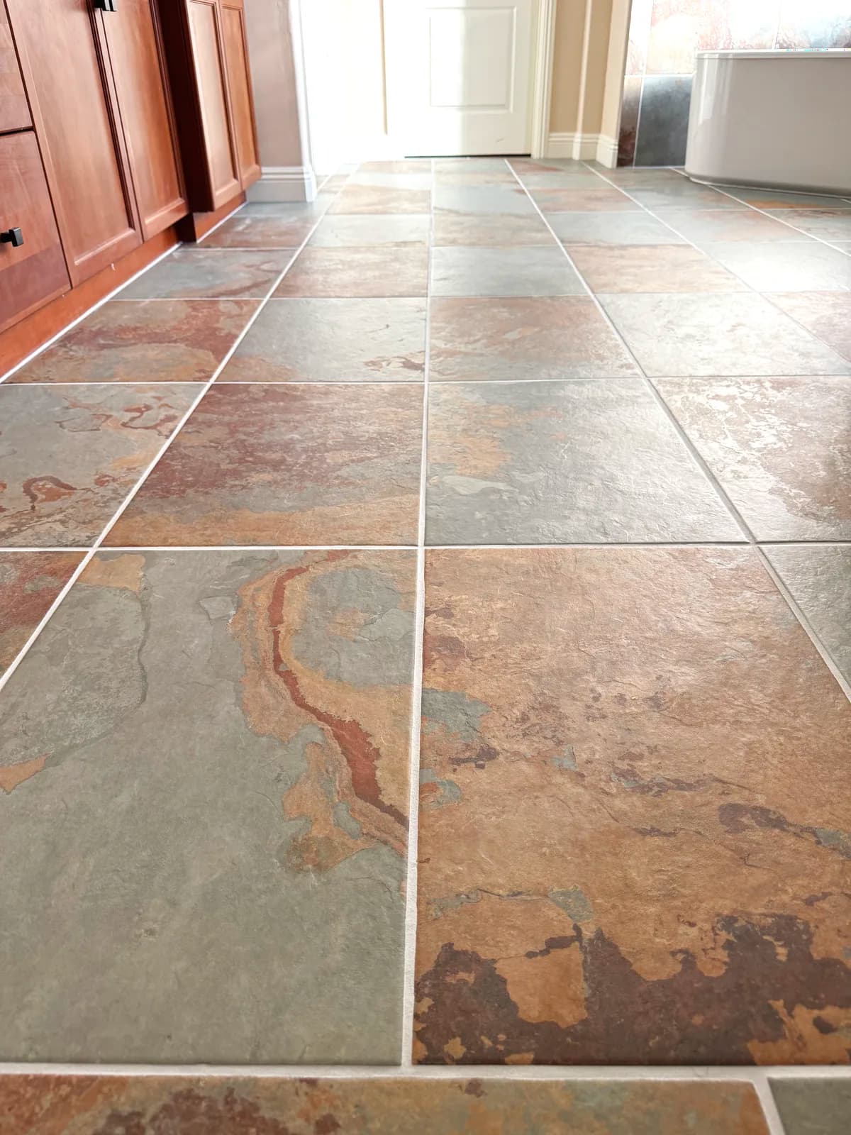 After: close-up of slate-look porcelain tile in grey and rust tones