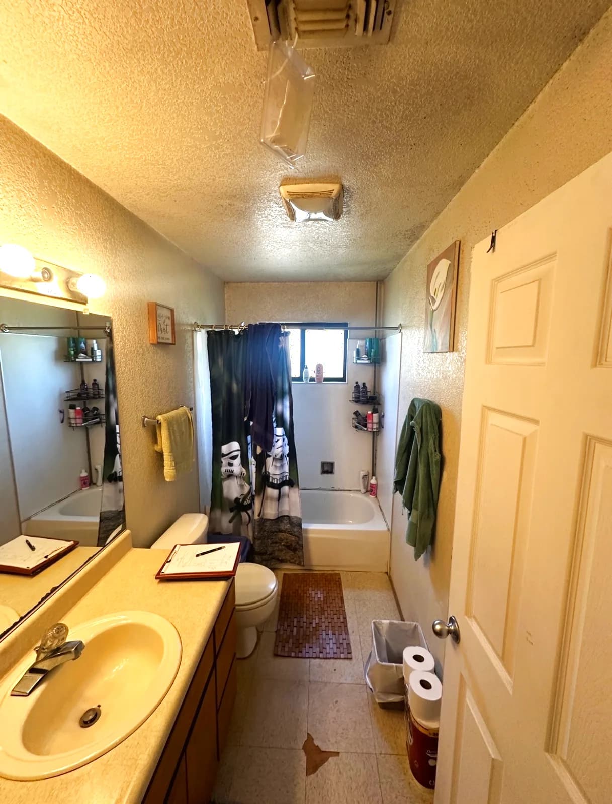 Before: Folsom hall bathroom with curtained tub, laminate vanity and vinyl floor
