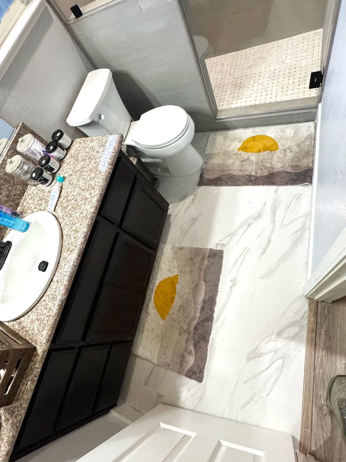 After: marble-look porcelain and vanity outside the shower