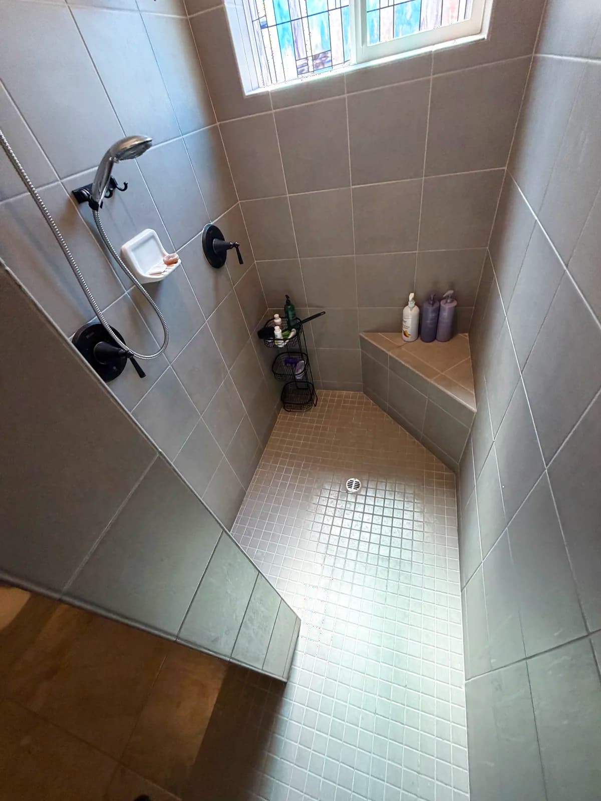 Before: Roseville bathroom shower doorway at wheelchair height showing the stepped tile curb and tight opening