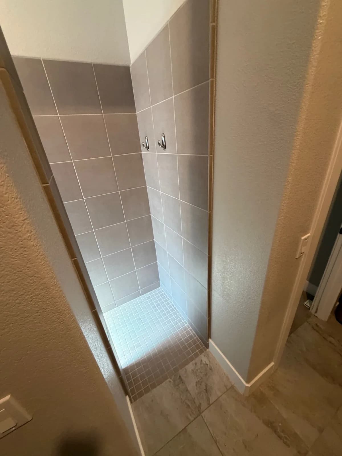 Before: Roseville shower from inside looking at grey wall tile and cramped entry opening
