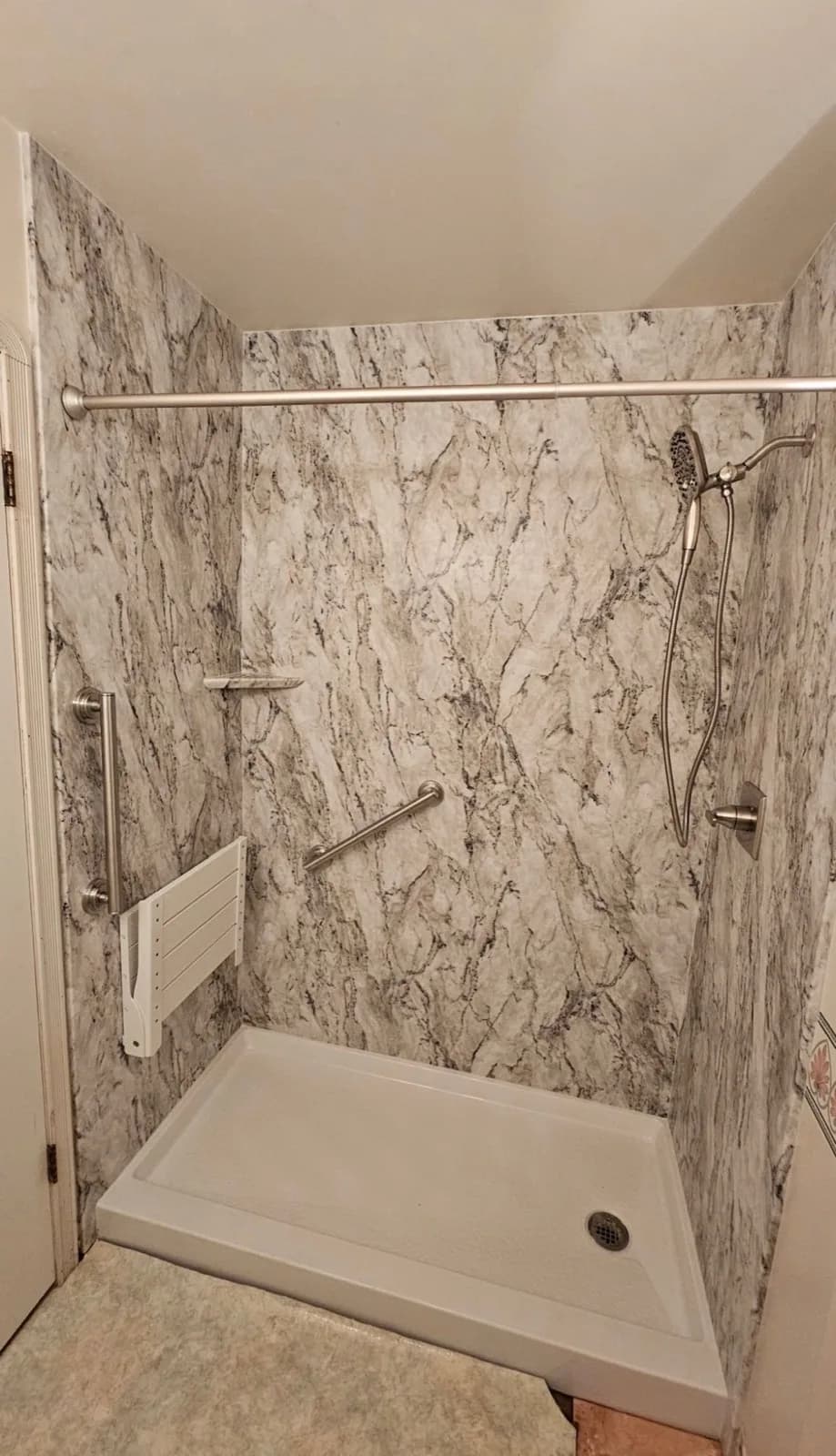 After: Roseville first acrylic shower — marble-look white acrylic wall panels, fold-down bench, handheld shower and curtain rod