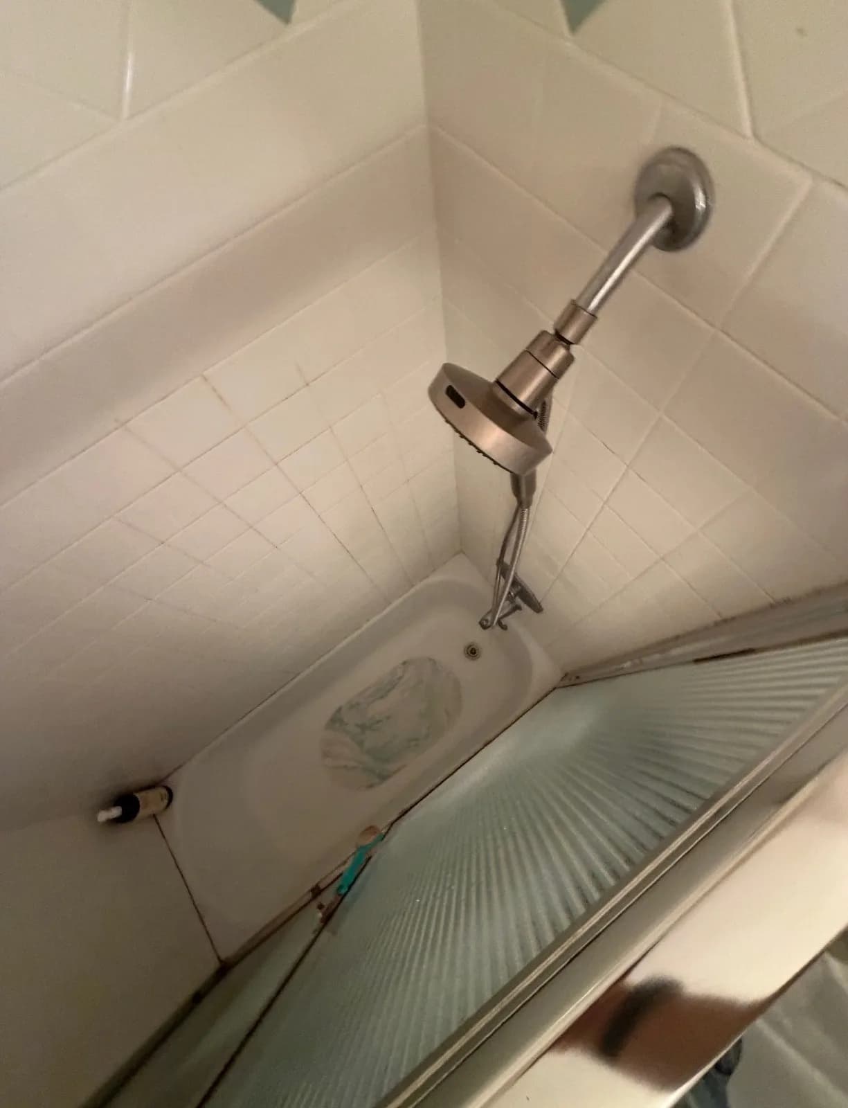Before: Roseville second bathroom shower — dated white square tile with framed glass door and old chrome fixtures