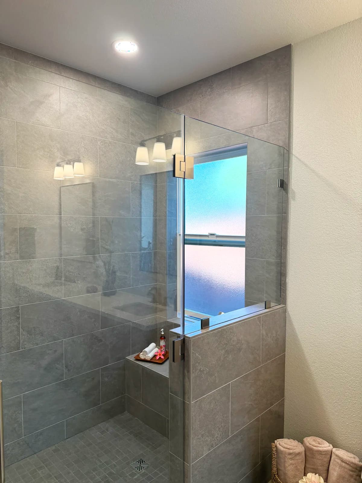 After: shower window and bench in large-format grey porcelain tile