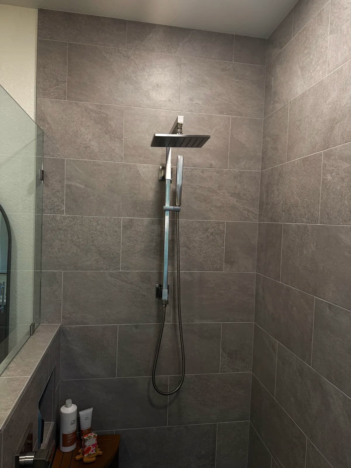 After: rain shower head with handheld on a slide bar against grey porcelain tile