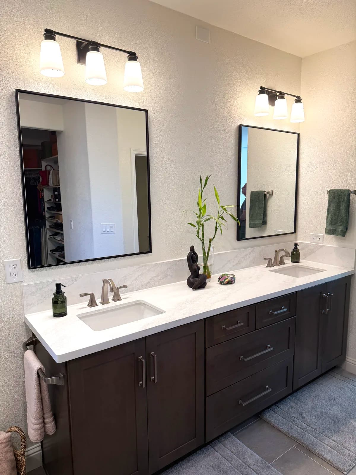 After: vanity wall with undermount sinks, brushed faucets and black-framed mirrors