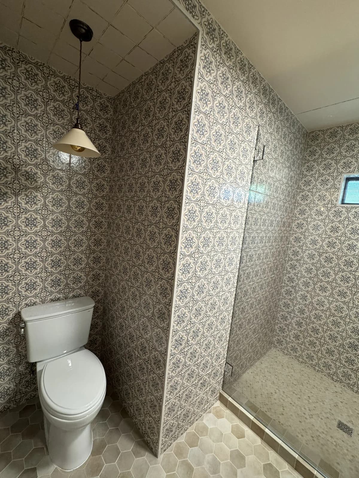 After: Arden bathroom with vintage Moroccan tile on the shower floor and the toilet area pony wall, hex tile visible in the main floor