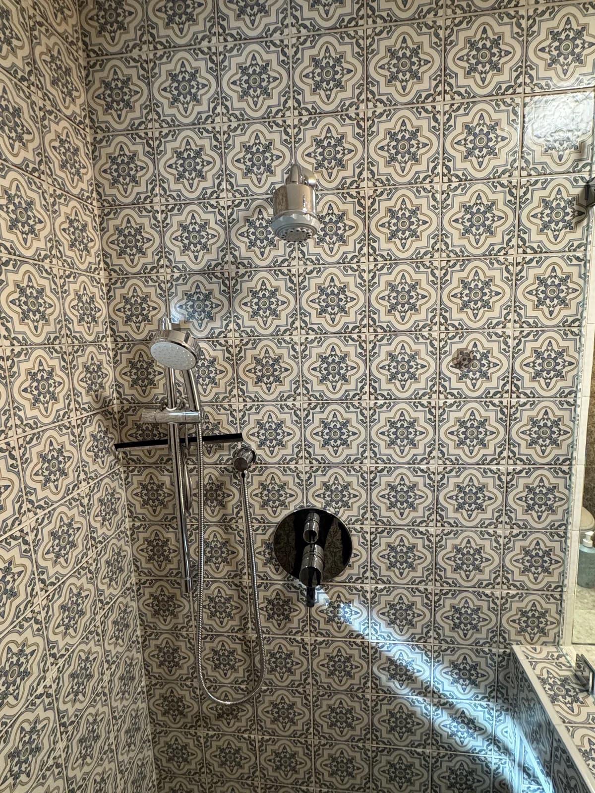 After: Arden hallway bathroom glass shower enclosure and hex marble floor tile transition