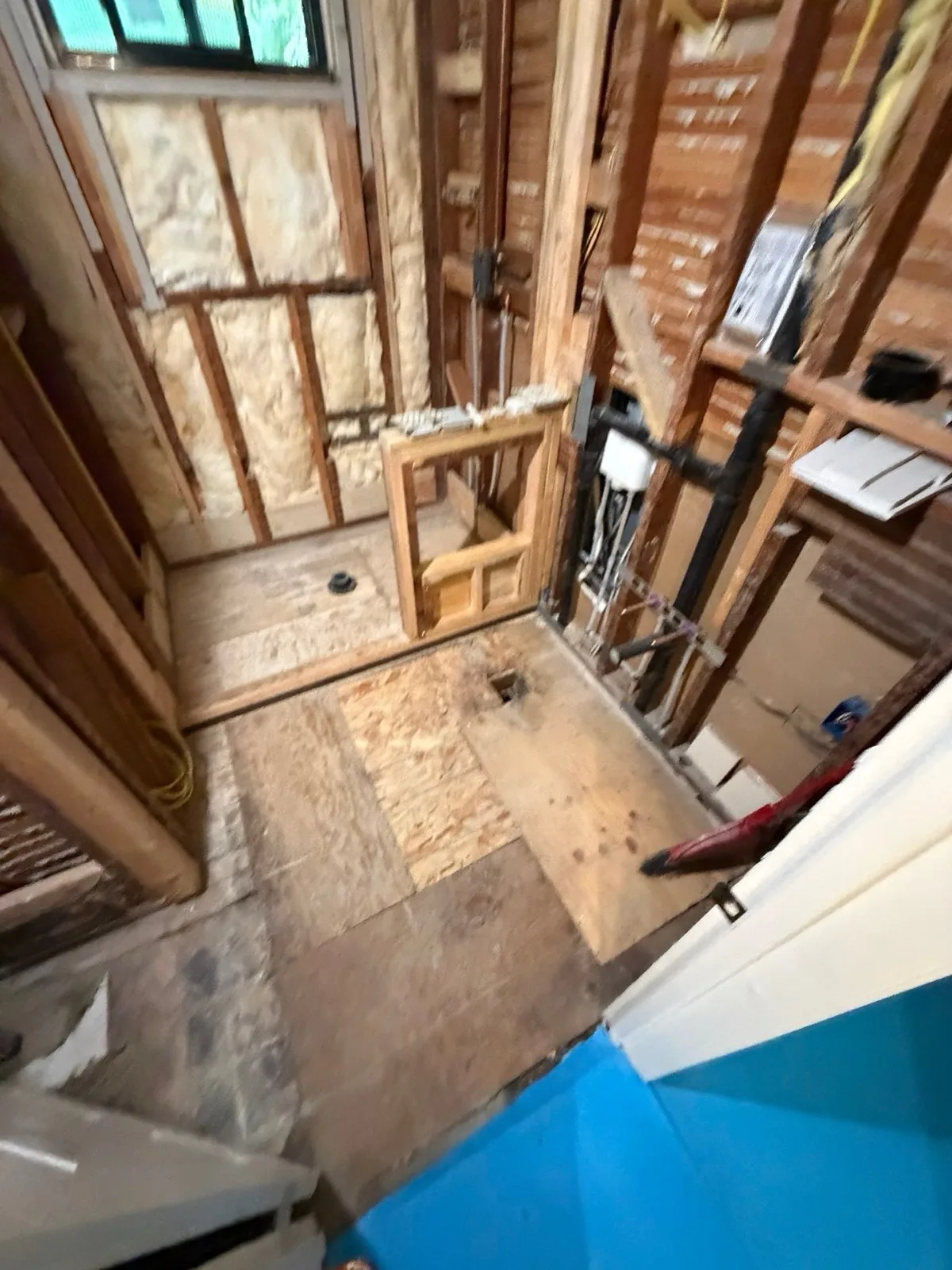 Before: Arden bathroom showing full depth of gutted shower area and rough subfloor