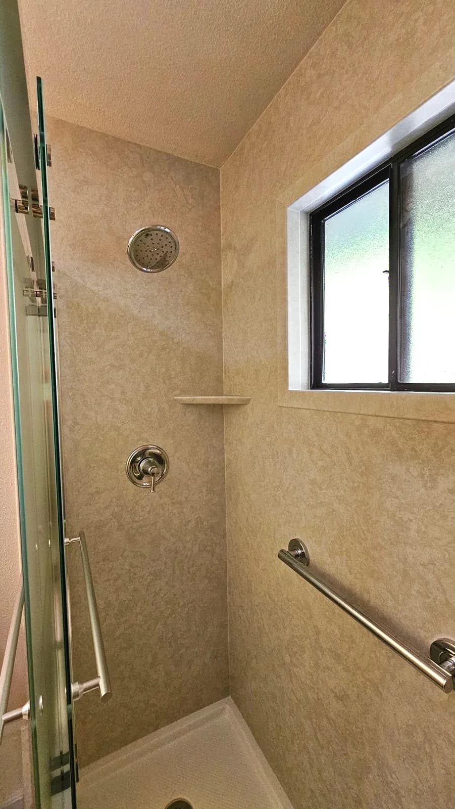 After: low-threshold shower base, chrome grab bar and acrylic-wrapped window inside an Auburn tub-to-shower conversion