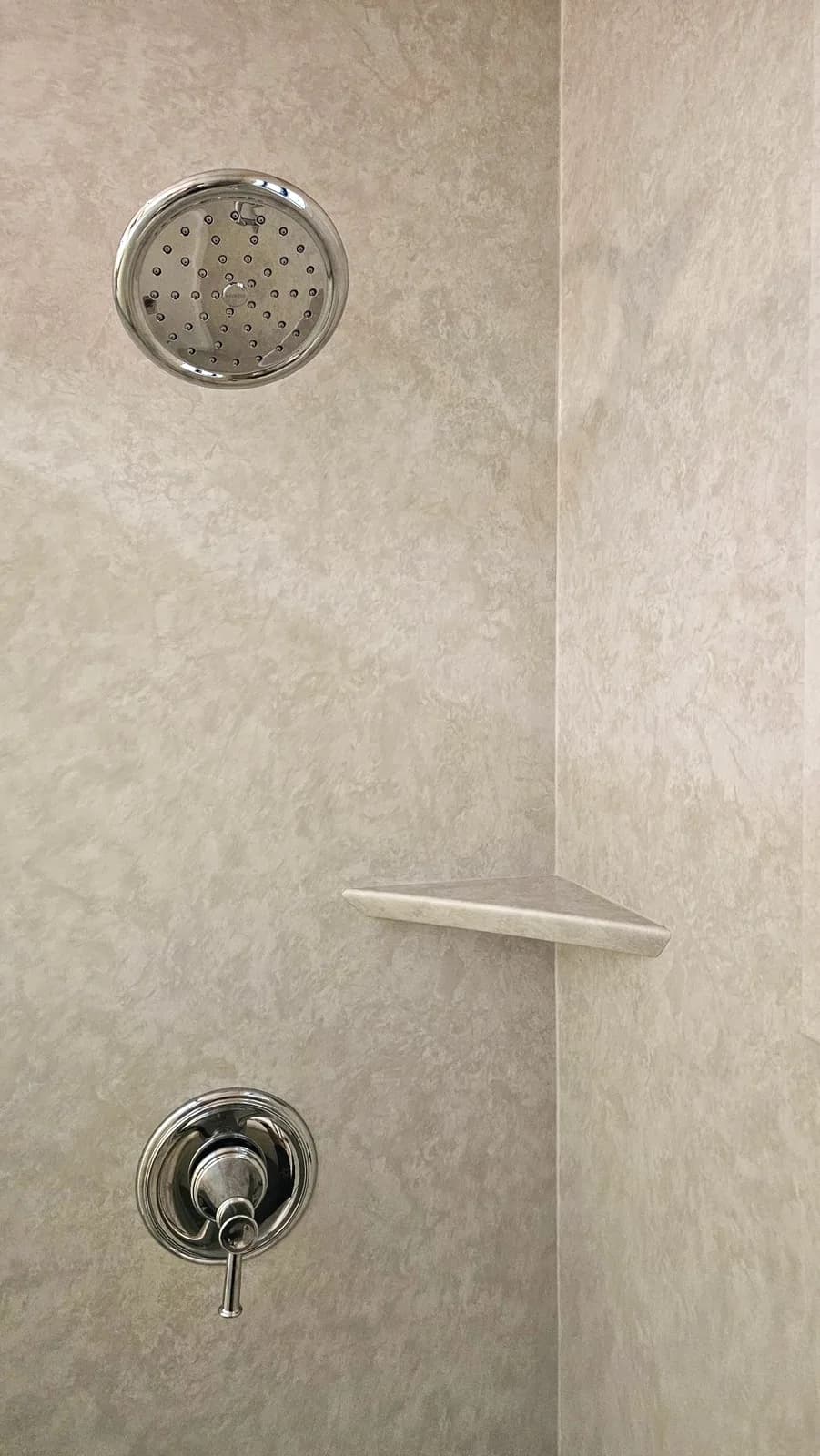 After: chrome rain shower head, single-handle valve and corner shelf on beige acrylic shower panels