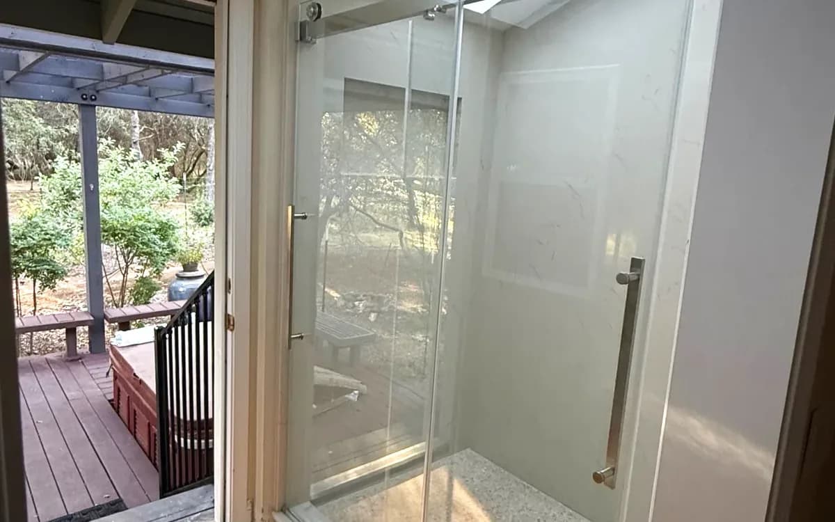 Frameless glass shower and skylight seen from the bathroom door