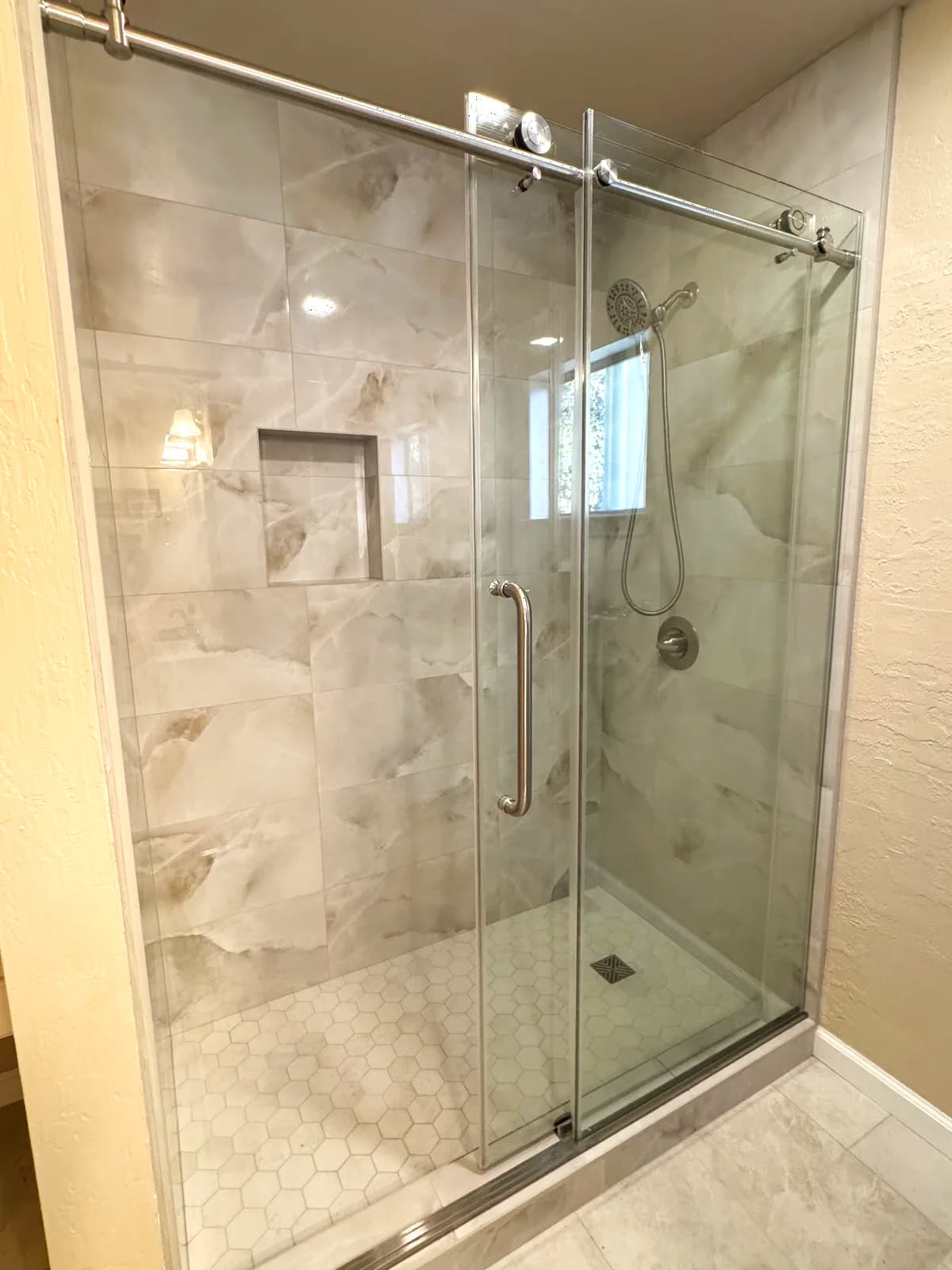 After: hex marble mosaic accent wall, recessed niche and brushed nickel grab bar
