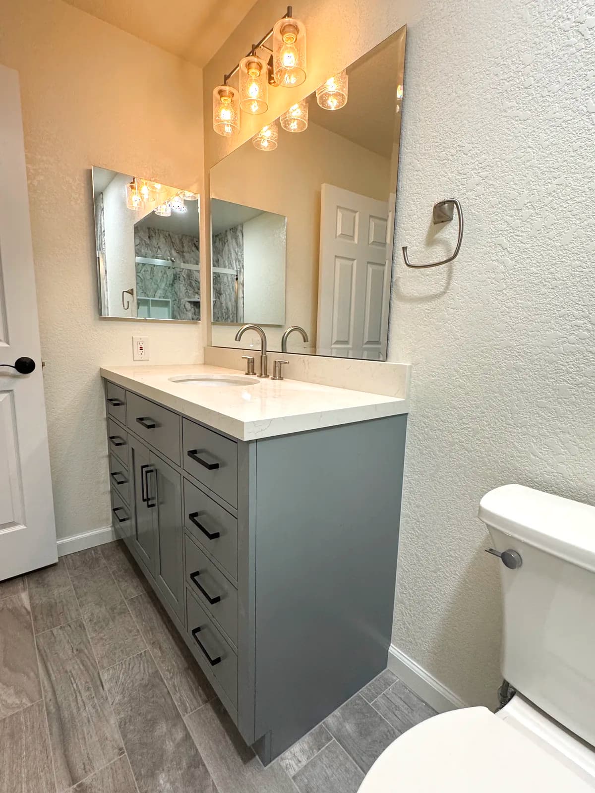After: grey shaker vanity with white quartz top, framed mirror and chrome multi-globe light in a Citrus Heights master bathroom
