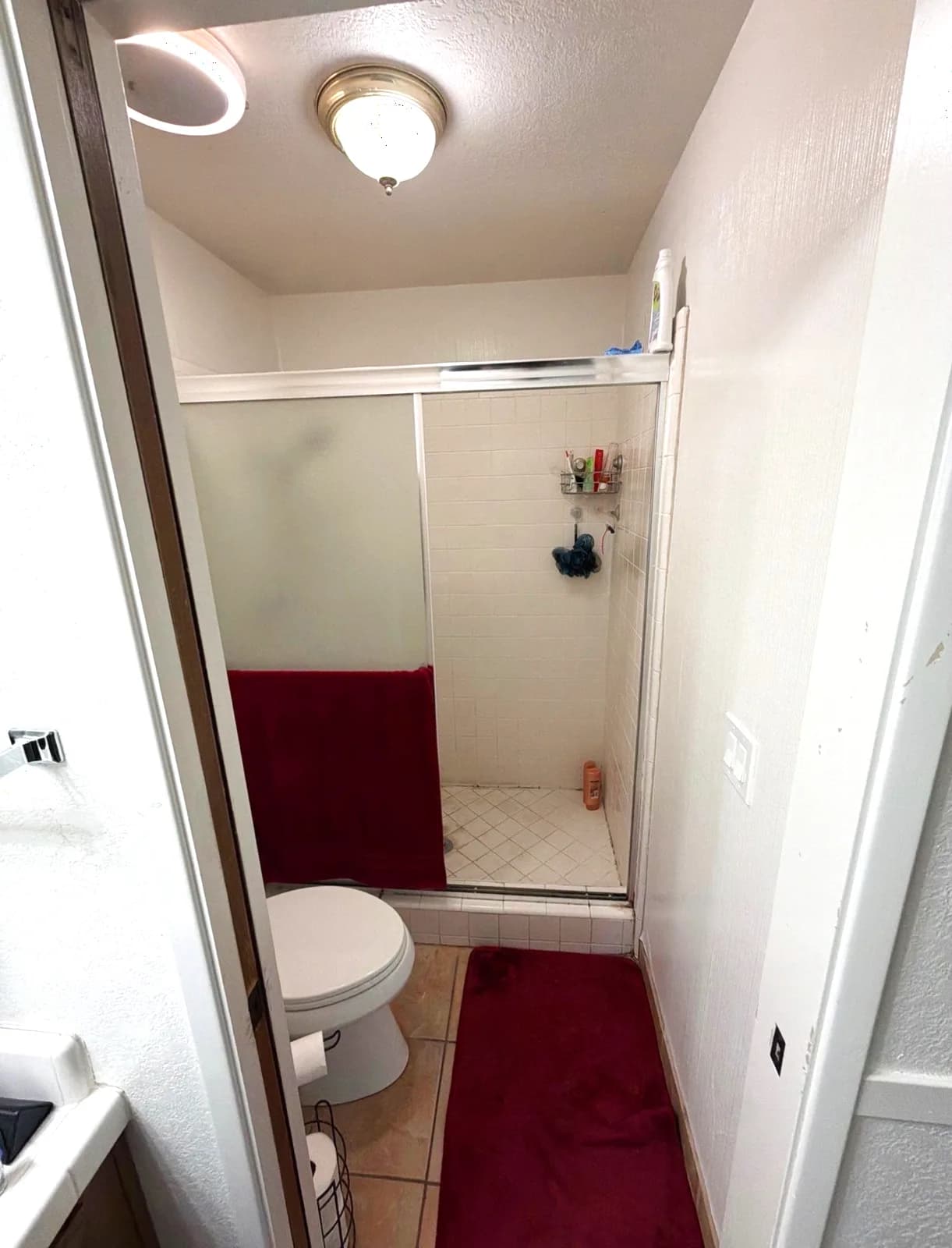 Before: dated master bathroom shower and toilet with tile flooring in Citrus Heights, CA