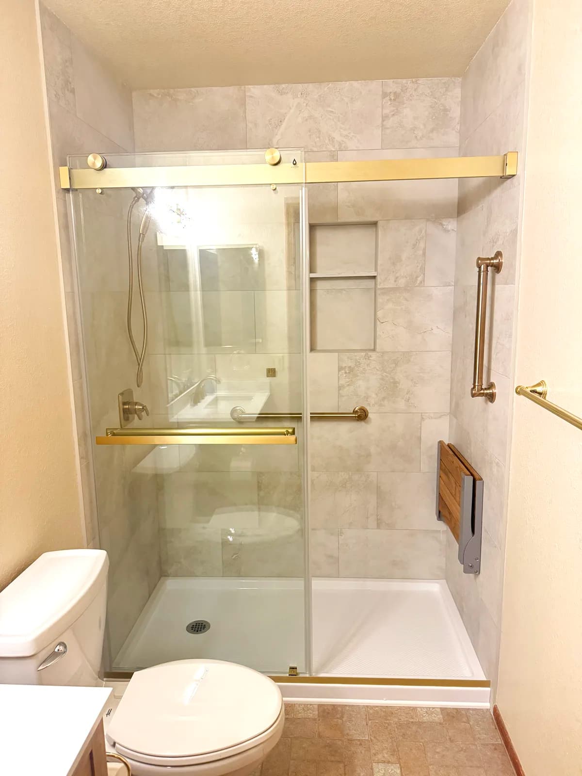 After: walk-in shower with stone-look porcelain, two niches and brushed gold fixtures in Orangevale, CA