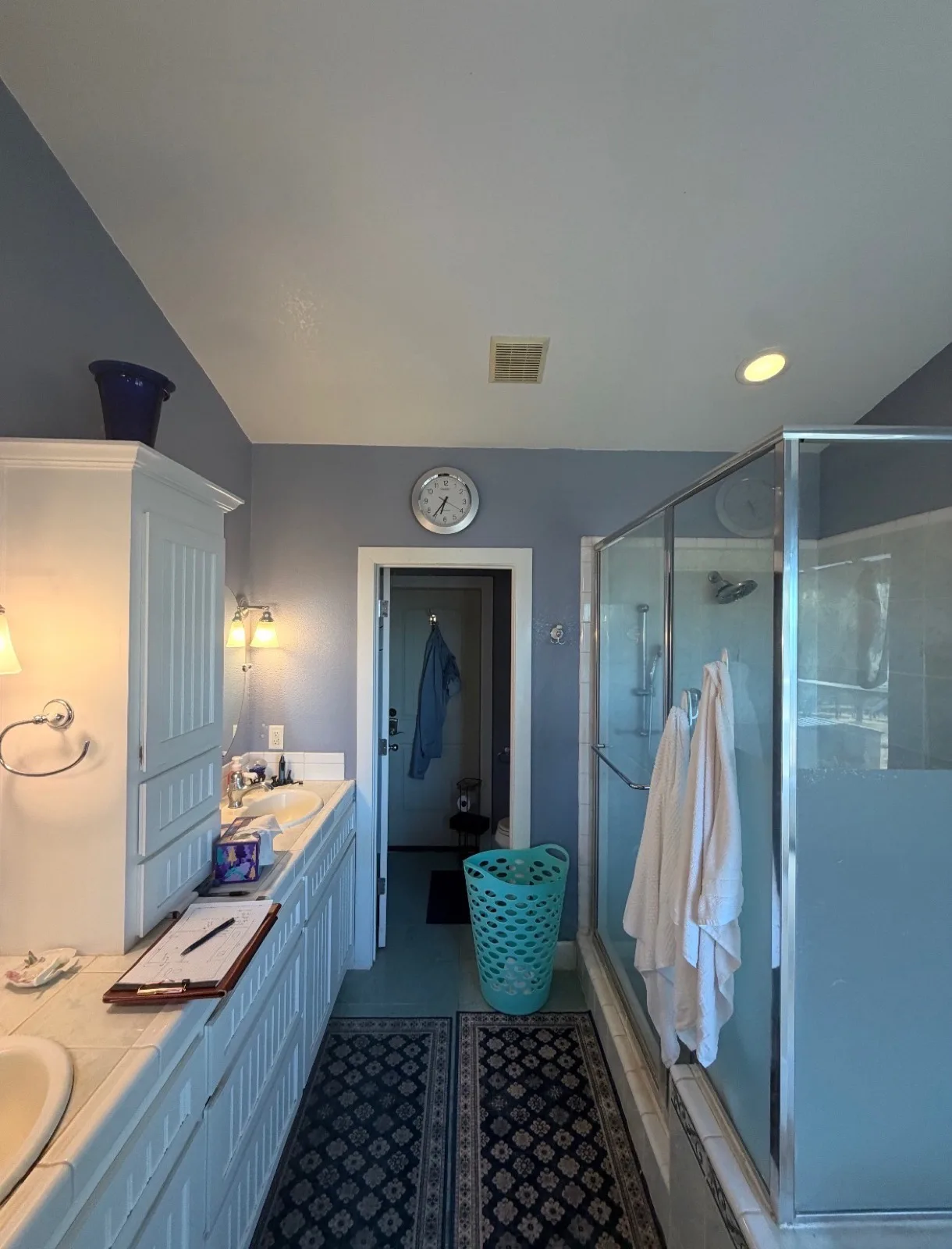 Before: Pilot Hill master bathroom showing white beadboard double vanity with tile countertop, lavender walls and the framed shower