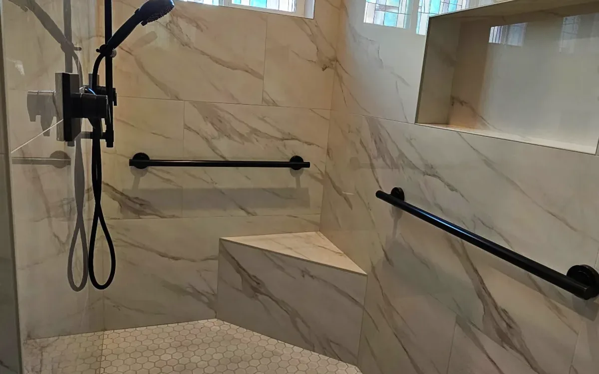 Curbless roll-in shower with a matte black rain head, a handheld on a slide bar and grab bars in Roseville, CA