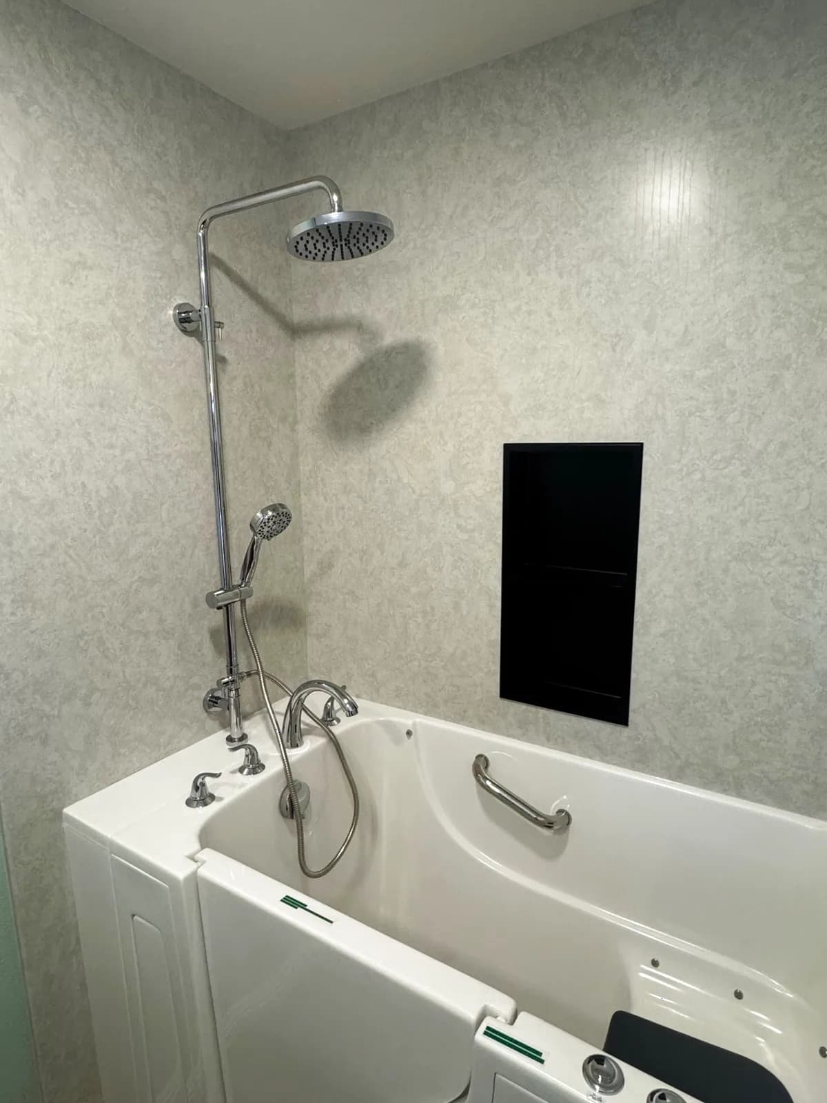 After: close-up of the Roseville walk-in tub chrome shower column with rain head, handheld on slide bar, chrome bath spout and an interior grab bar