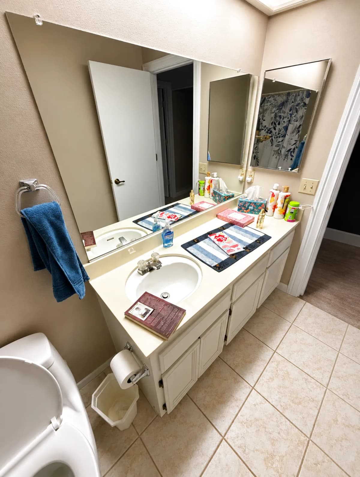Before: Roseville bathroom double vanity with cultured-marble top, two oval drop-in sinks and white laminate cabinets