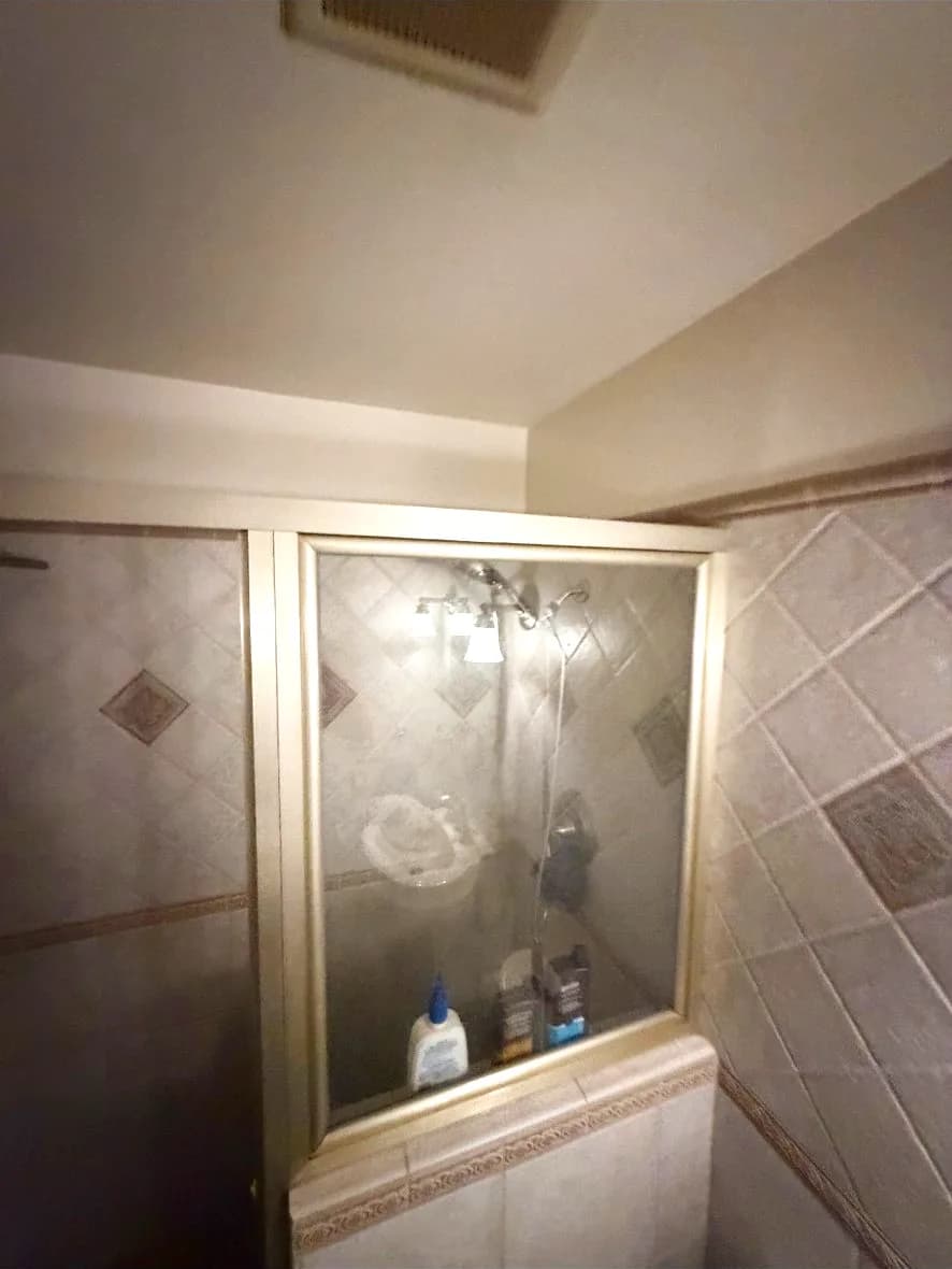 Before: Woodland hallway bathroom shower with framed glass panels, diamond-set tile walls and a tiled half wall